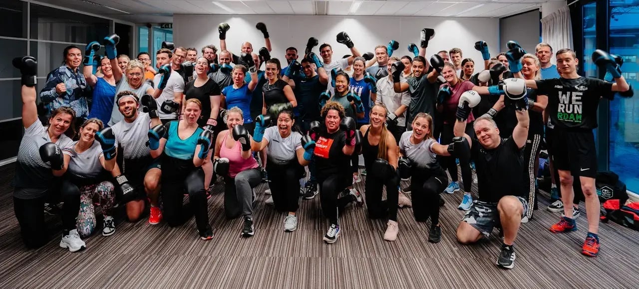 Group photo of employees wearing boxing gloves.