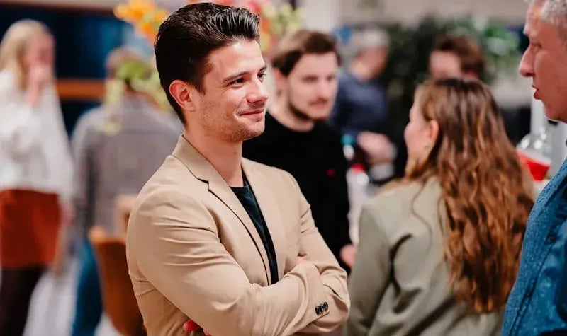 Two men standing and talking at a gathering.