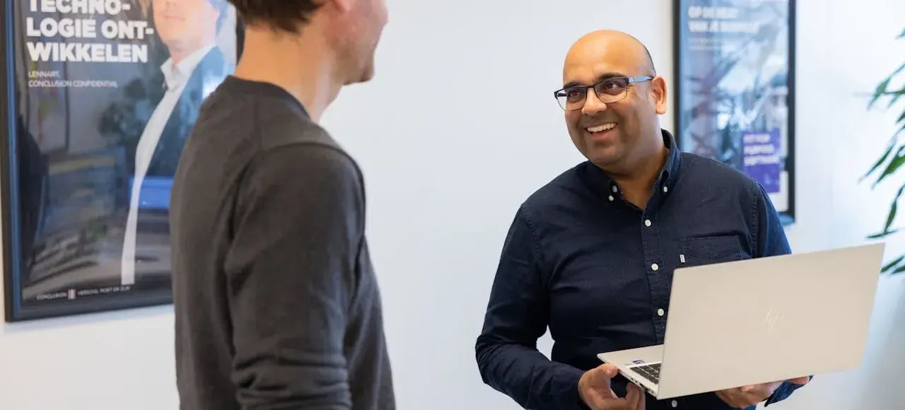 Twee mannelijke collega's praten met elkaar