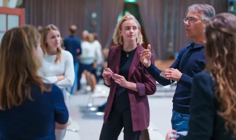 Collega's die in een groepje staan en met elkaar aan het praten zijn. 