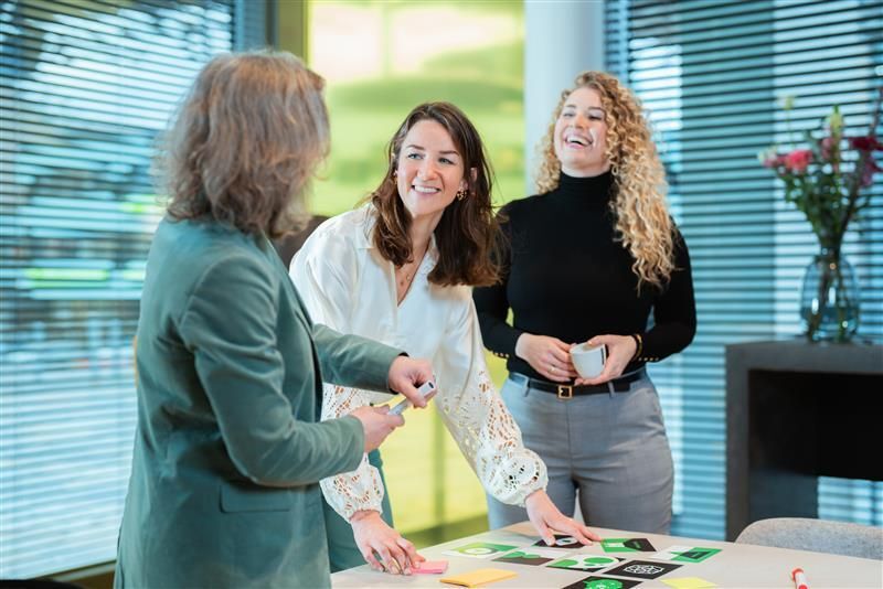 Vrouwen lachen met elkaar op kantoor.