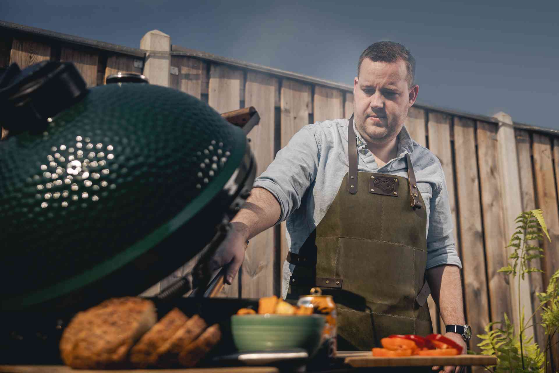 Man kookt op de barbecue in de tuin.