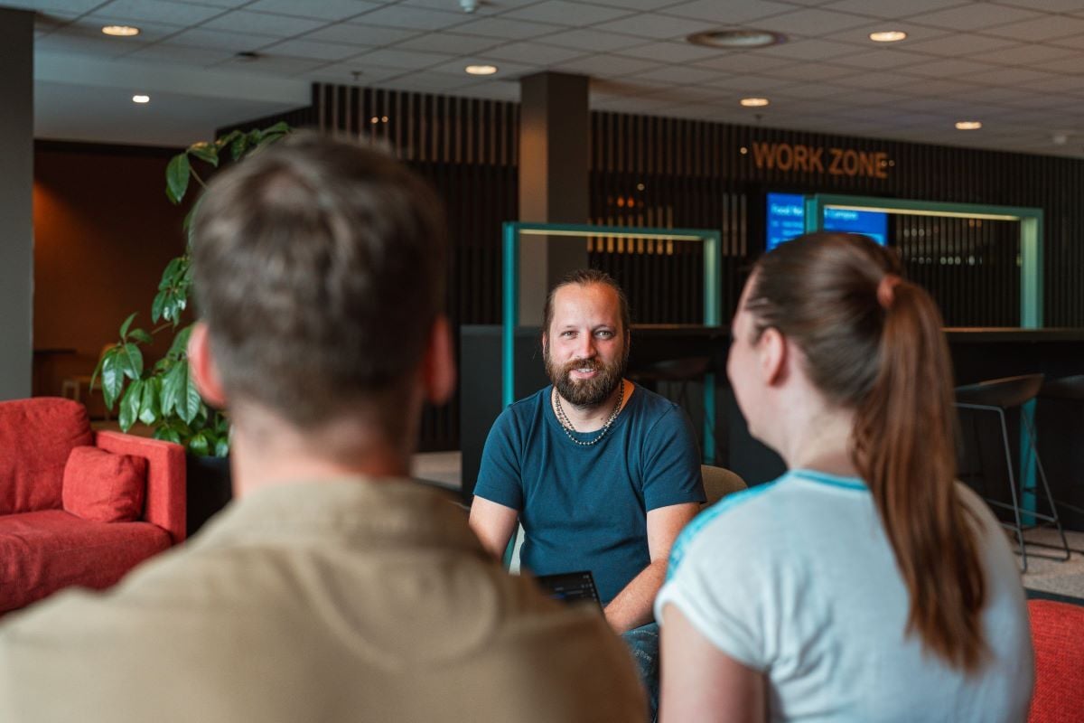 A conversation between colleagues in a modern workspace with an emphasis on collaboration and interaction.