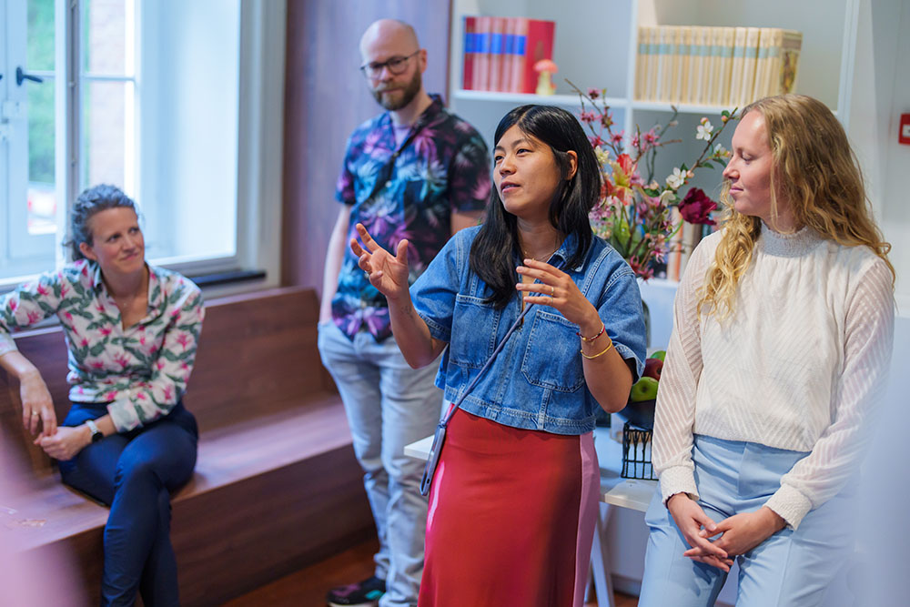 A woman gives a presentation while others listen attentively.