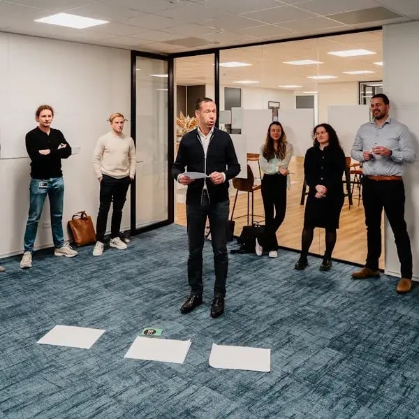 Man presenting with a sheet of paper in his hand.