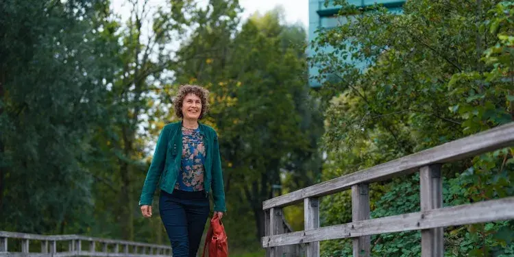 Vrouw loopt over brug in een park