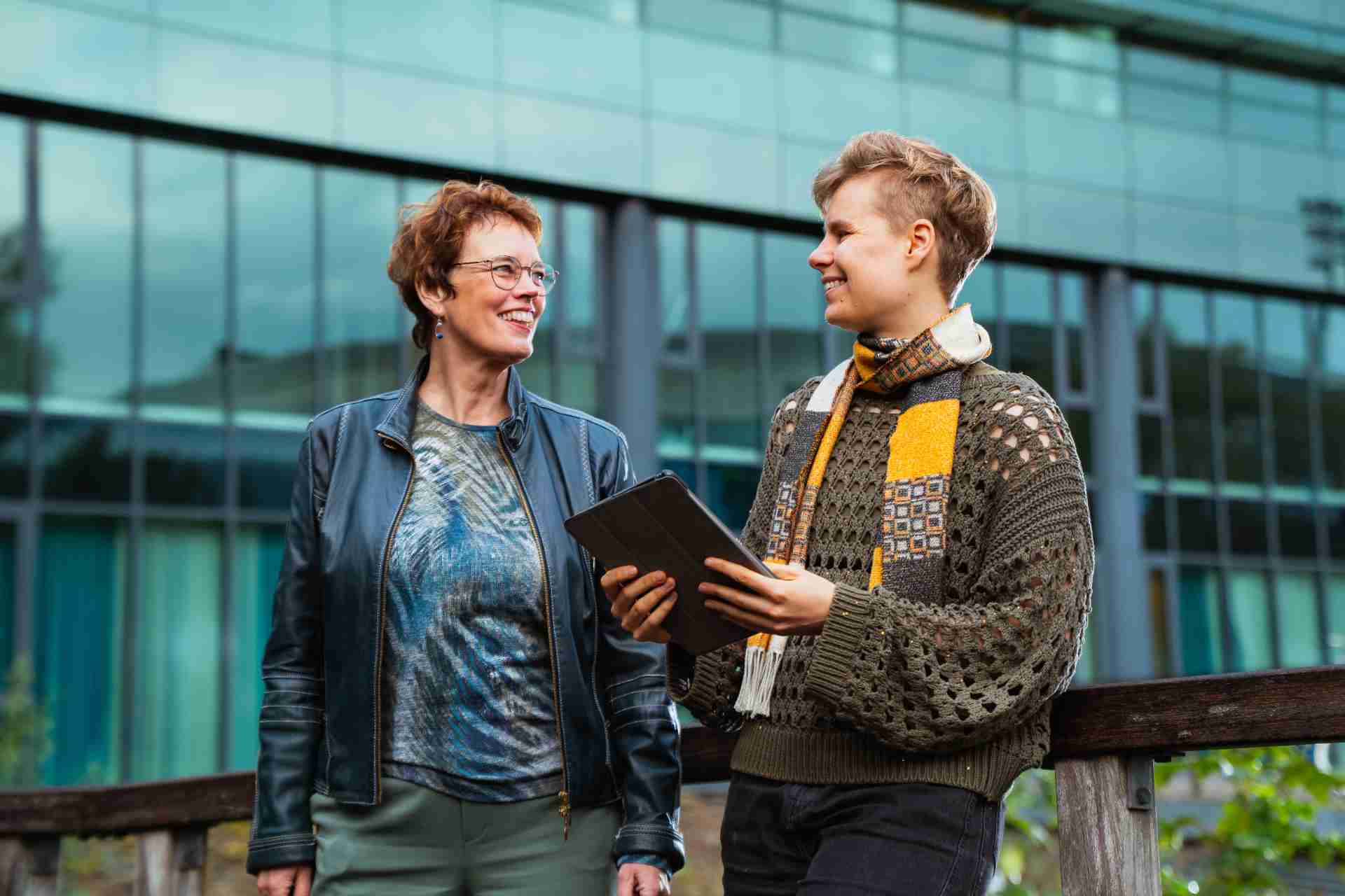 Twee vrouwen die buiten lopen met een tablet in de hand