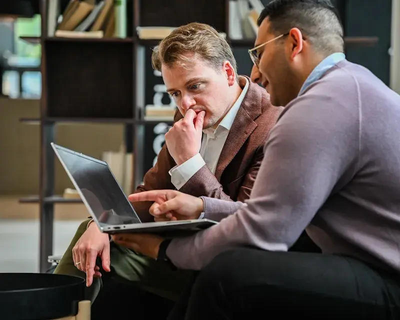 Two gentlemen looking at laptop screen